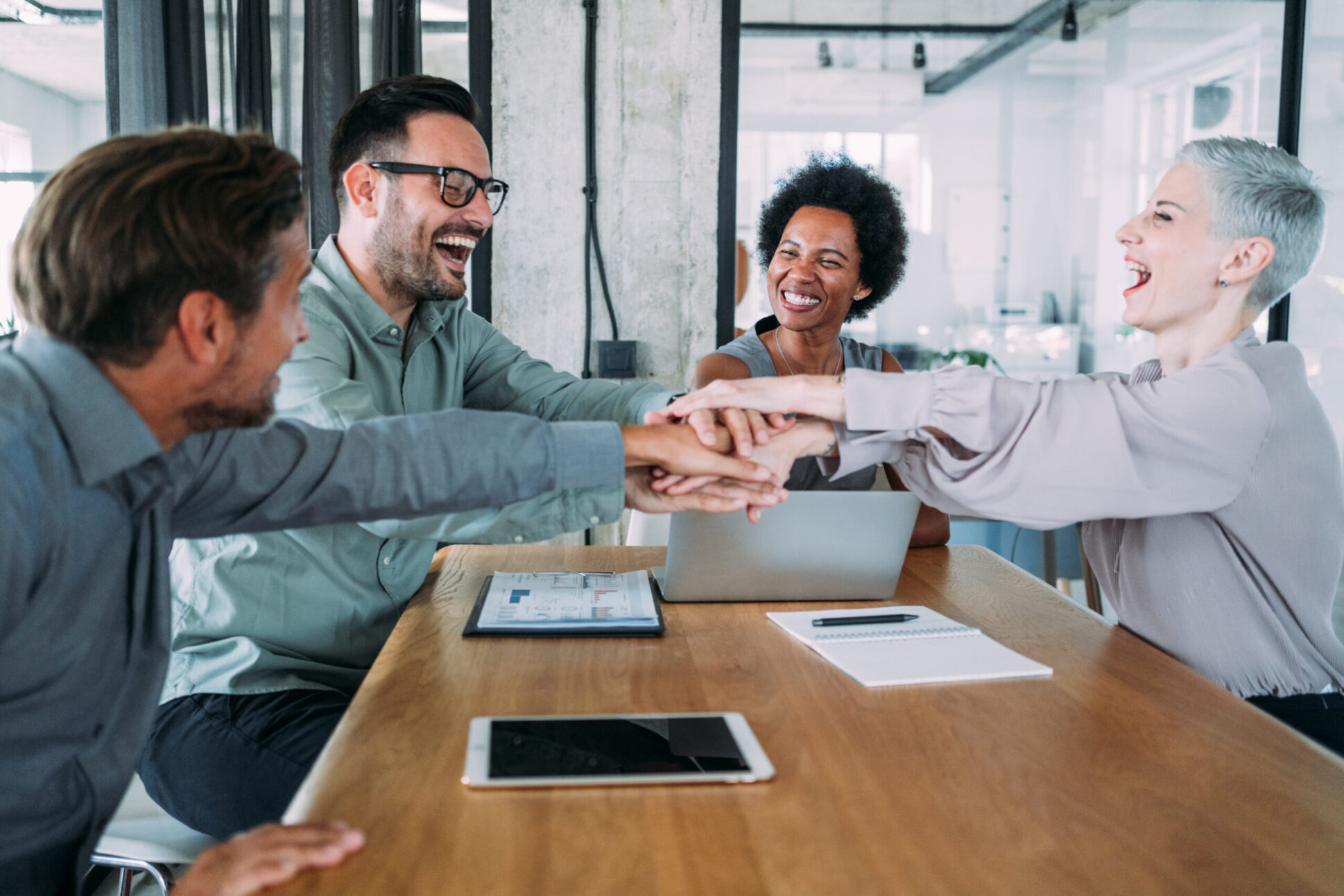 Shot of multiracial group of business people with stacked hands showing unity and teamwork. Successful business people stacking hands in the office.